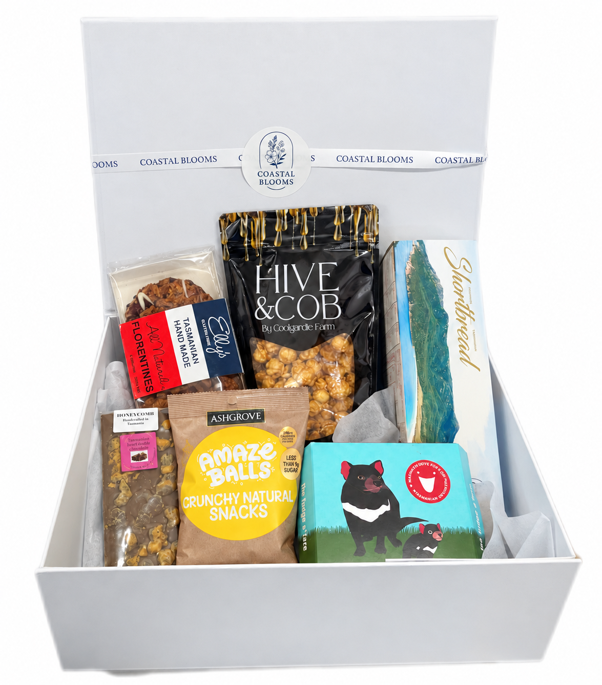 A Coastal Blooms gift box filled with assorted pet treats and snacks, including a bag of Hive & Cob popcorn treats, a bag of Amaze Balls natural cheese snacks, and a box of Tasmanian Shortbread, arranged inside a white gift box. All 100% Tasmanian gourmet treats. 